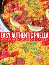 spanish paella in skillet topped with lemon wedges
