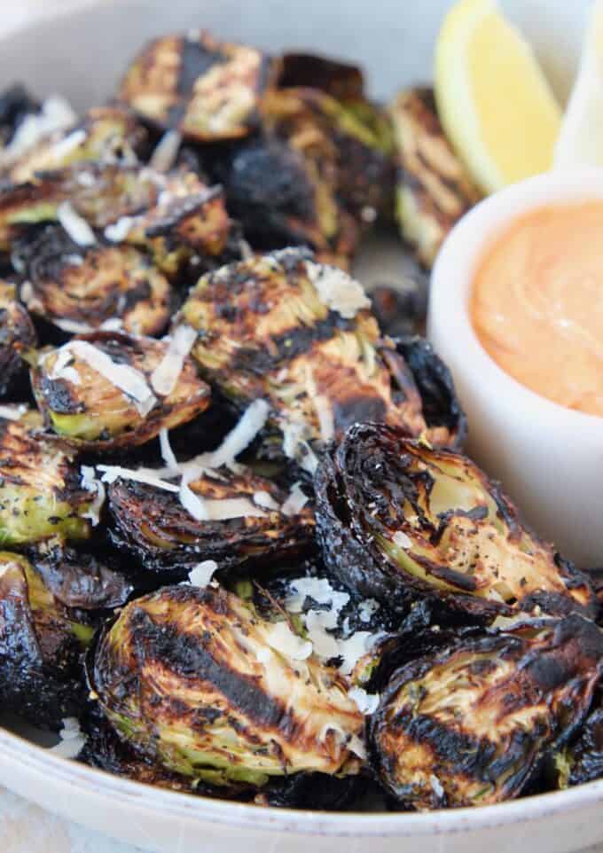 grilled brussels sprouts in bowl with dipping sauce