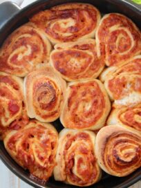 cooked pizza rolls in black baking dish
