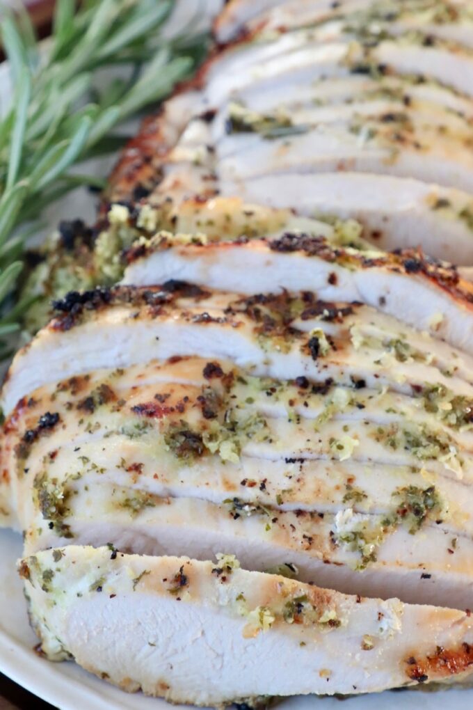 slices of turkey on a plate with fresh herbs