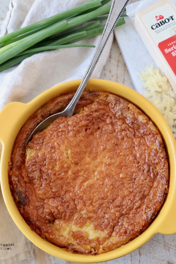 corn casserole in baking dish with serving spoon