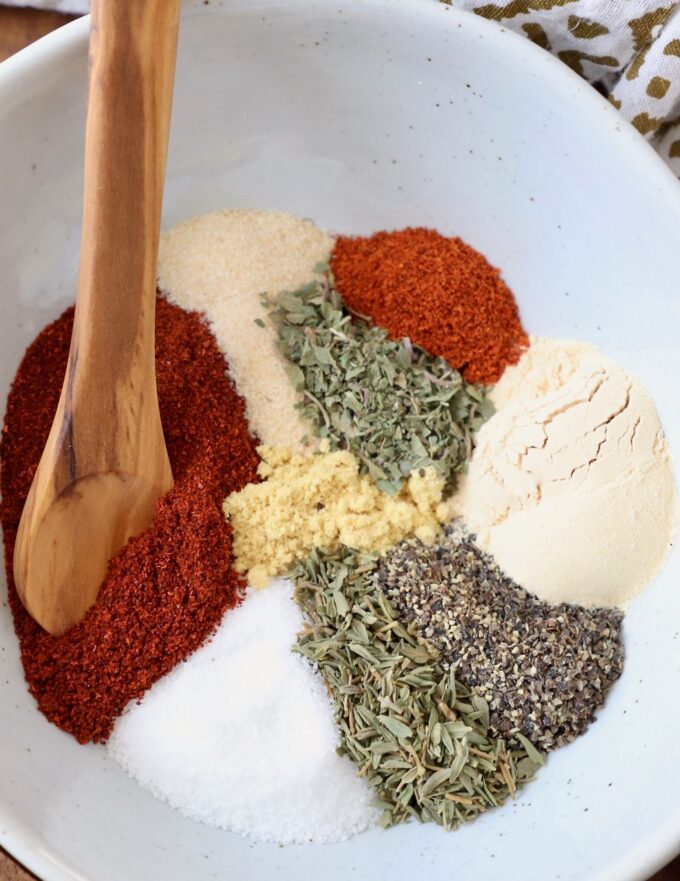 herbs and spices in bowl with wooden spoon