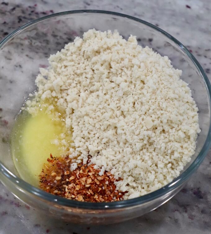panko breadcrumbs with melted butter and seasonings in glass bowl