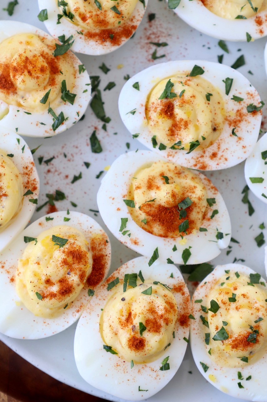 overhead image of deviled eggs on plate topped with fresh chopped parsley