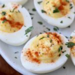 deviled eggs on plate topped with fresh chopped parsley
