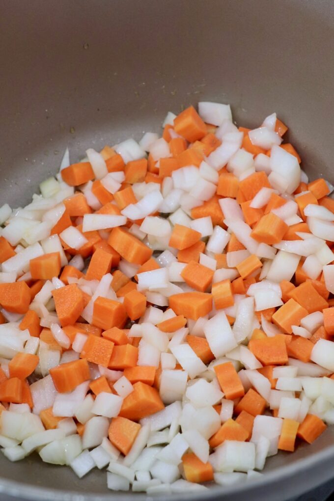 diced carrots and onions in pot on the stove