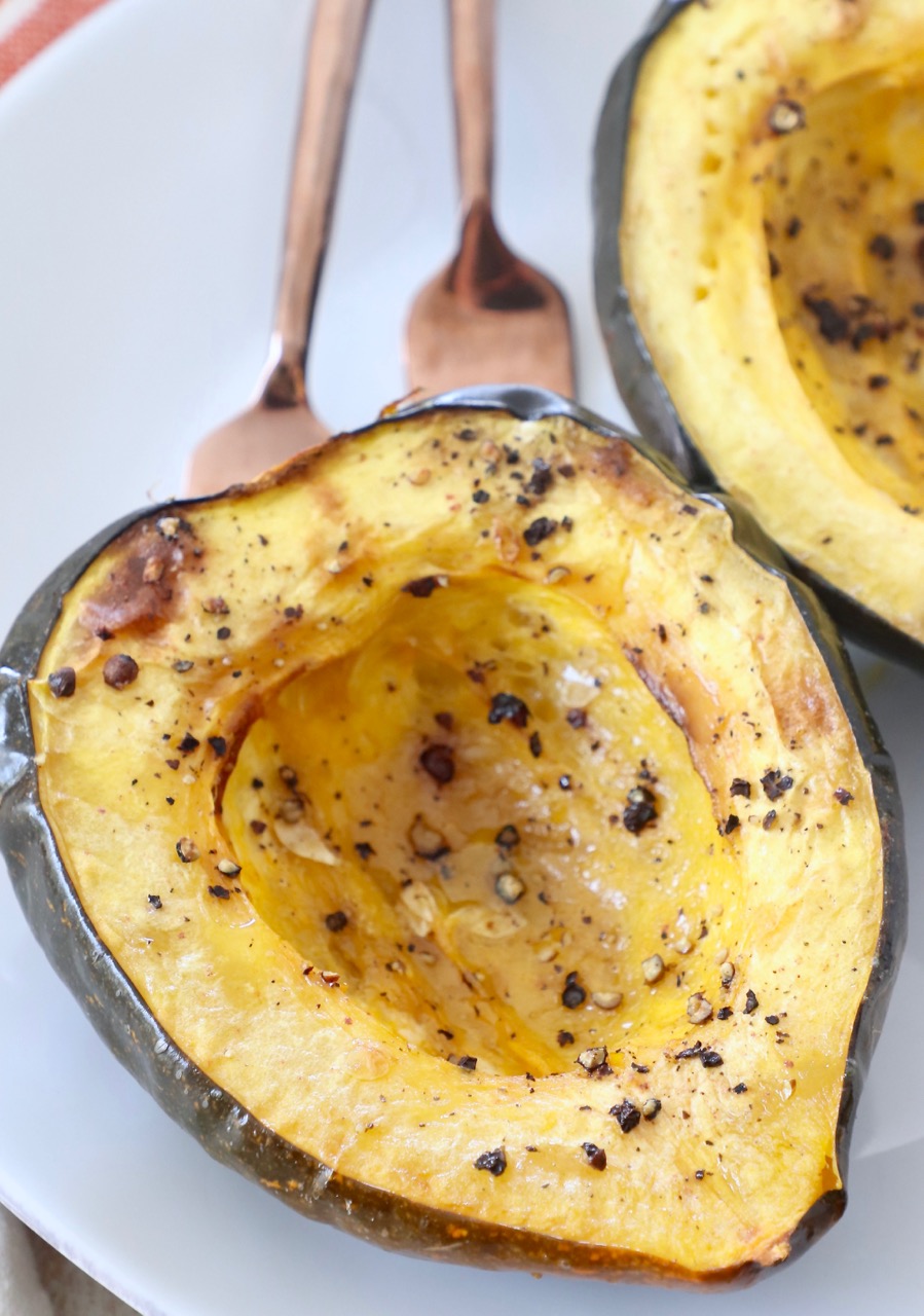 roasted acorn squash cut in half on plate with two forks