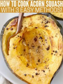 cooked acorn squash cut in half on plate with fork