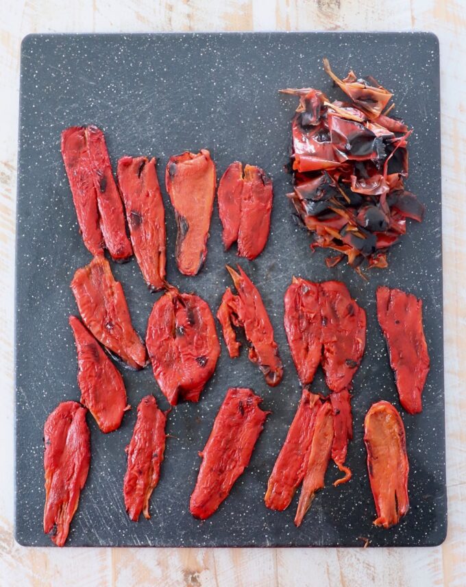 strips of peeled roasted red peppers on cutting board
