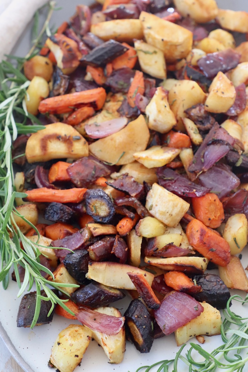 roasted cubed vegetables on plate with fresh sprigs of rosemary