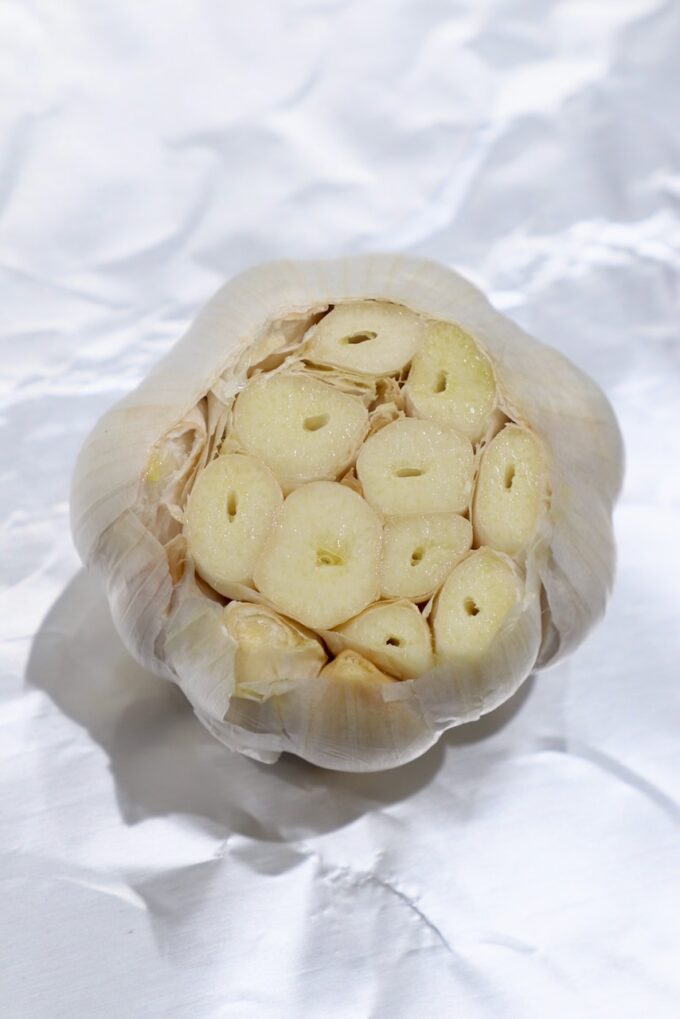 head of garlic with cloves exposed on piece of foil
