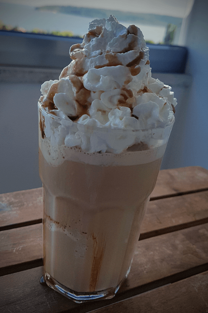 DIY Caramel Frappuccino in a glass with whipped cream topping