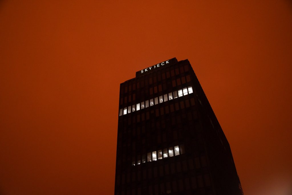 Wildfires leave the SkyDeck building on Shattuck surrounded by a dark and orange sky.