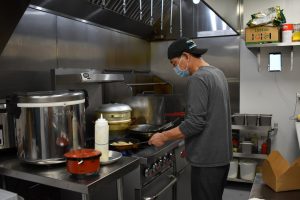 Keguang Zhao prepares one of Cozy Wok’s vegetarian specialties at the restaurant’s kitchen in Oakland. 