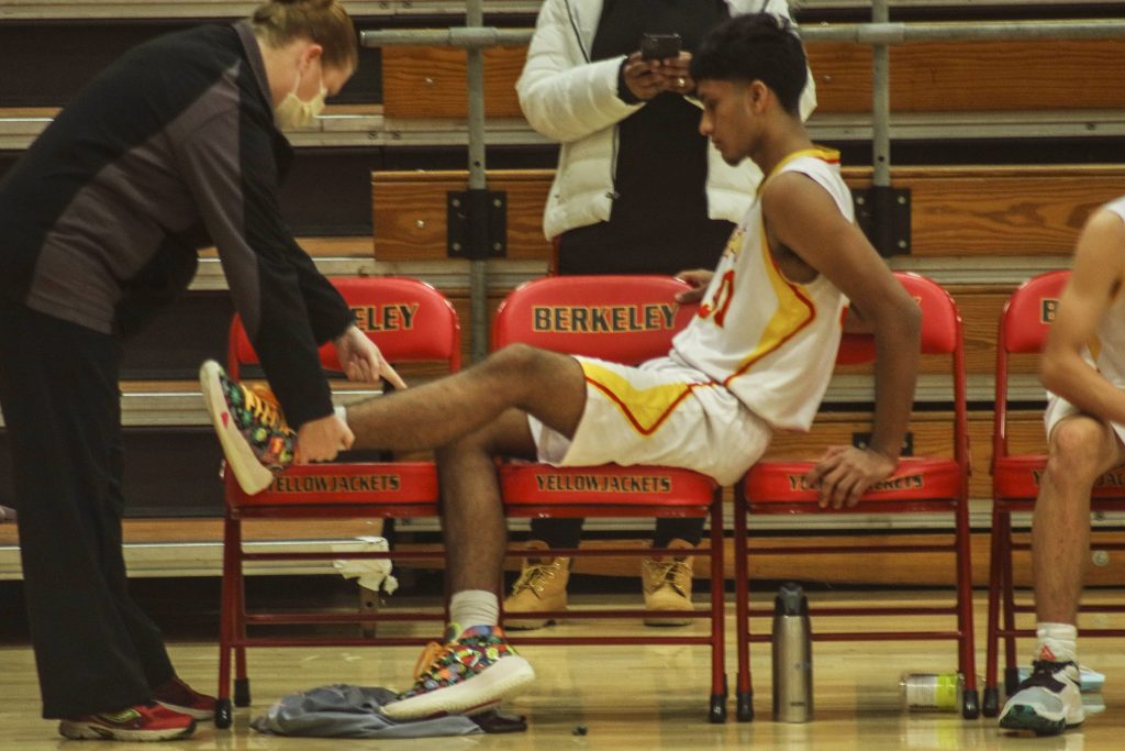 Freshman basketball player Manav Rai’s injury is examined during a home game.