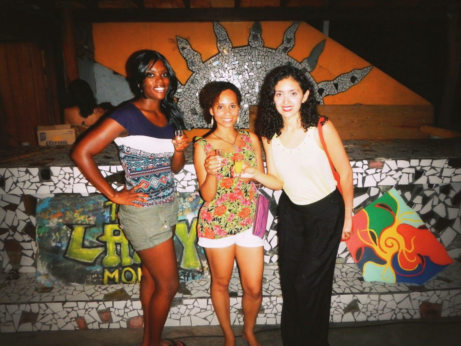 Three women standing near wall art in Costa Rica.