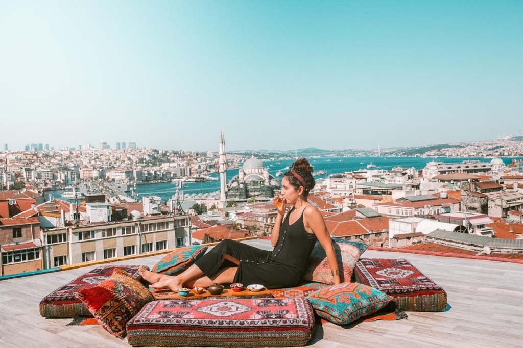 A woman sipping a drink on a rooftop in Istanbul