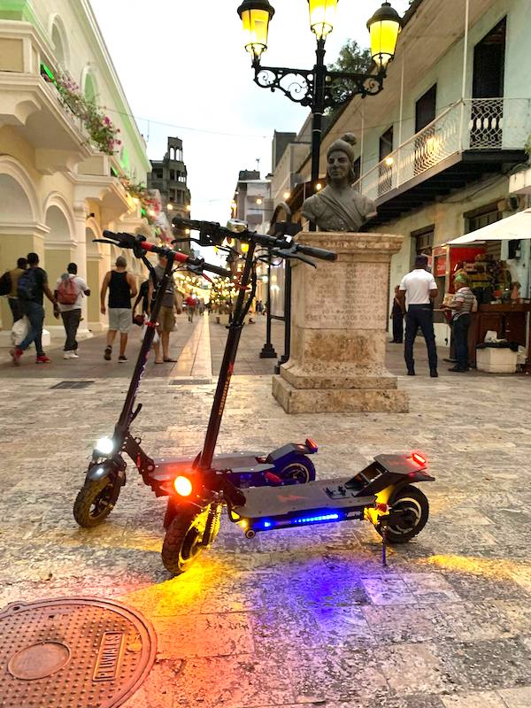 Two electric scooters parked near a statue at La Zona Colonial.
