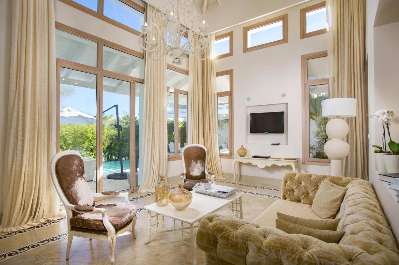 A living room with furniture and floor-to-ceiling curtains at a resort in the Dominican Republic.