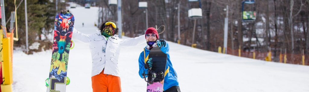 Two people holding a snowboard at Mountain Creek, NY in December