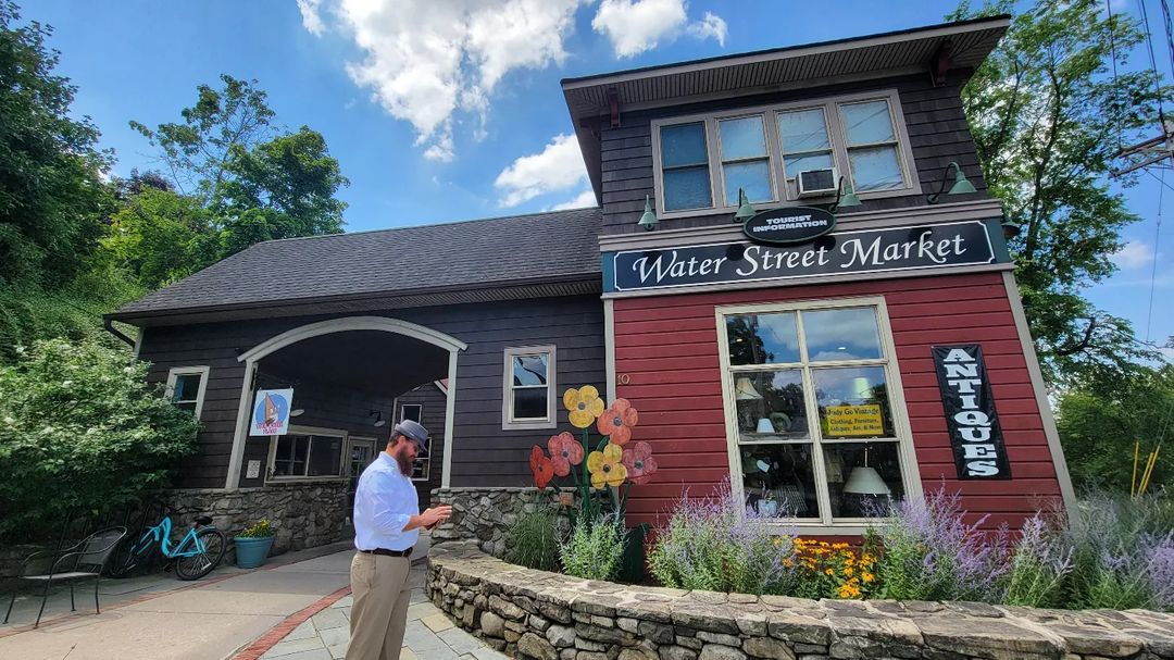 A man standing in front of an antique shop at Water Street Market, New Paltz