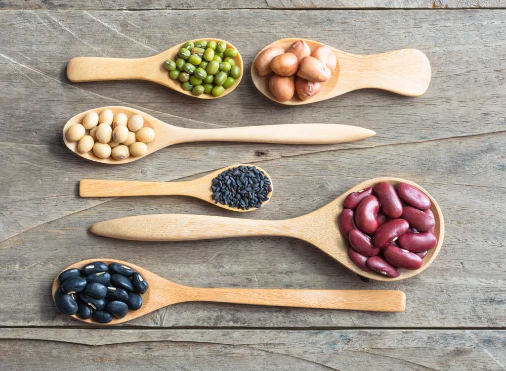 different beans on wooden spoons