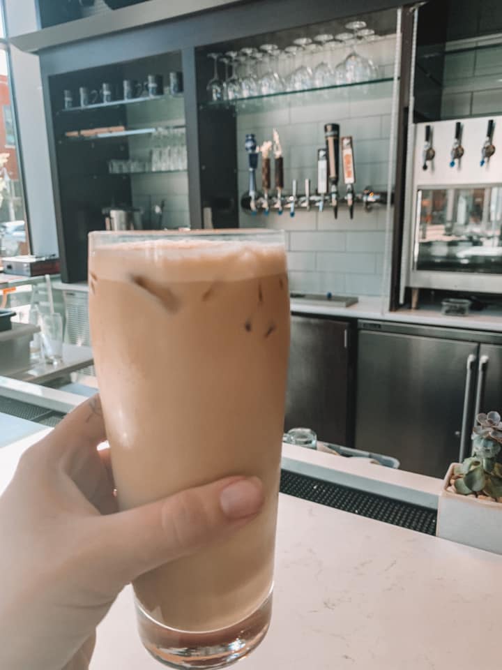 girl holding a glass of iced coffee at 42 & Lawrence