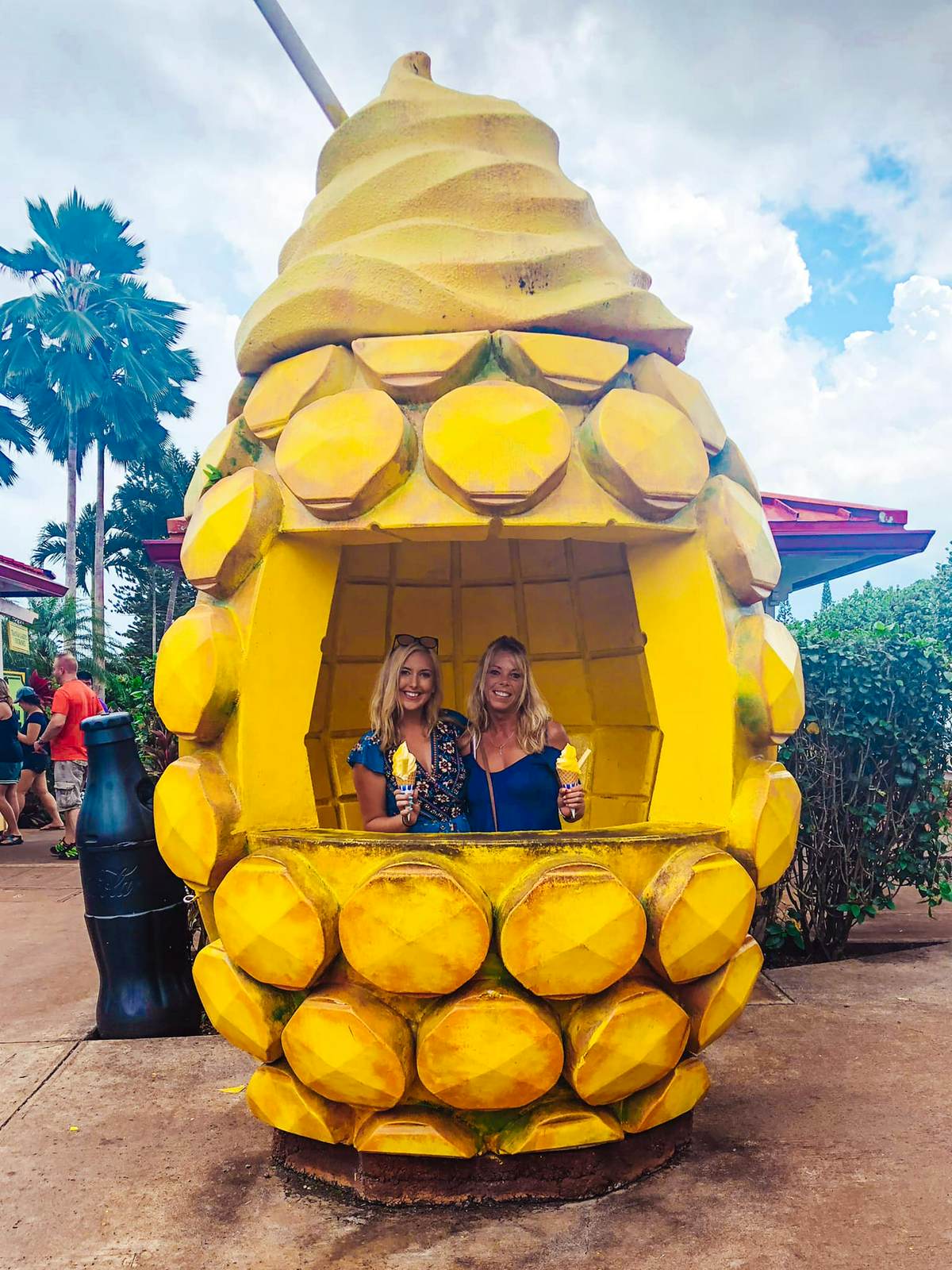 two women holding their dole whip inside of a giant pineapple at the Dole Plantation on Oahu's North Shore