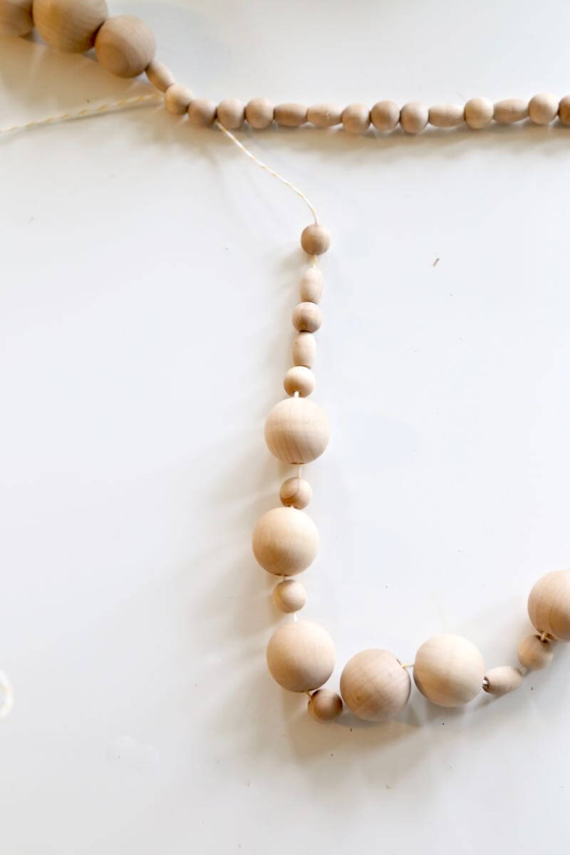 How to make a simple DIY wood bead garland. Perfect for your mantle at Christmas. This thing is so gorgeous, and so easy to make! 