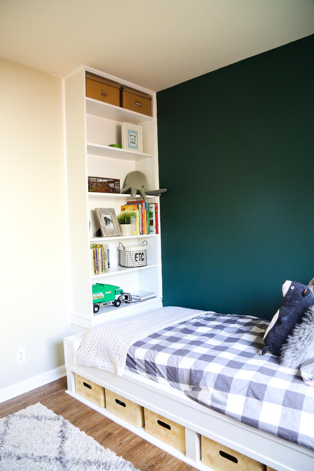 White built in bed and bookcase with grey bedding and green wall