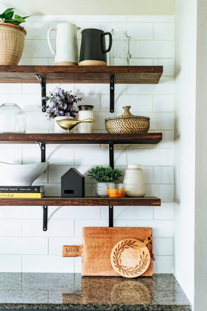 floating shelves in kitchen with two bread boards sitting on counter 