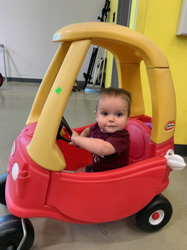small toddler in a Cozy Coupe car