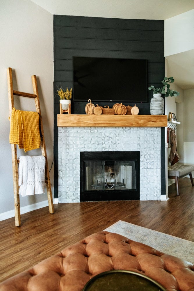fireplace decorated for fall with wooden carved pumpkins