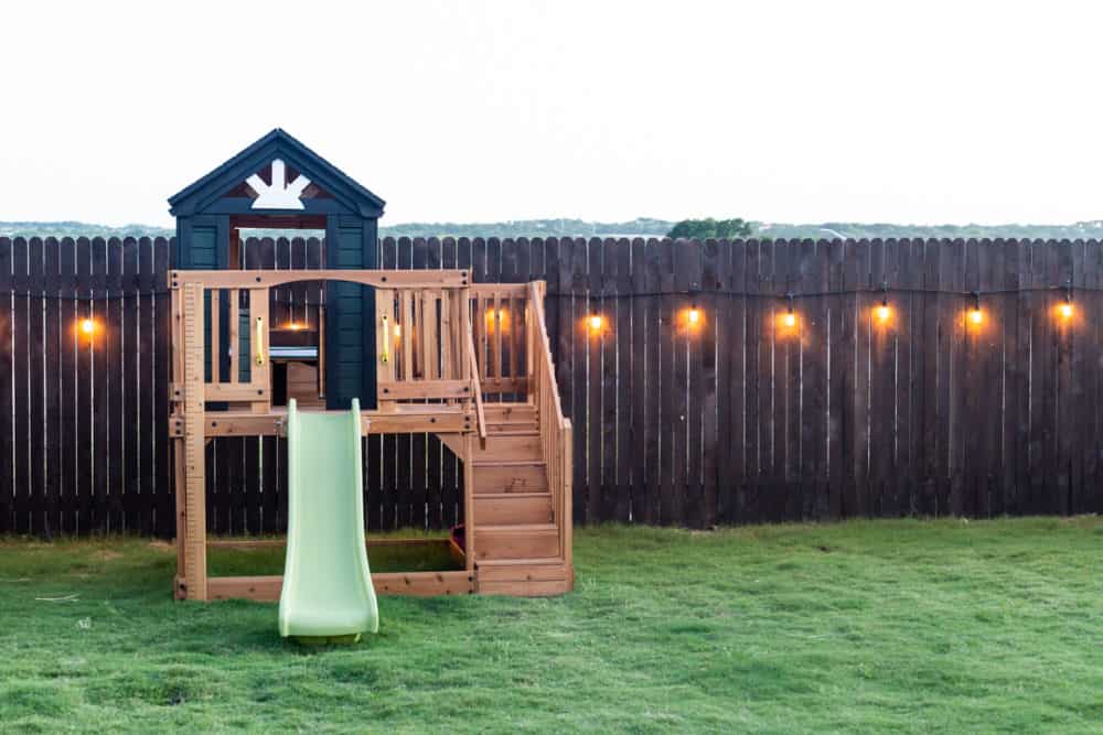small play structure near a lighted fence