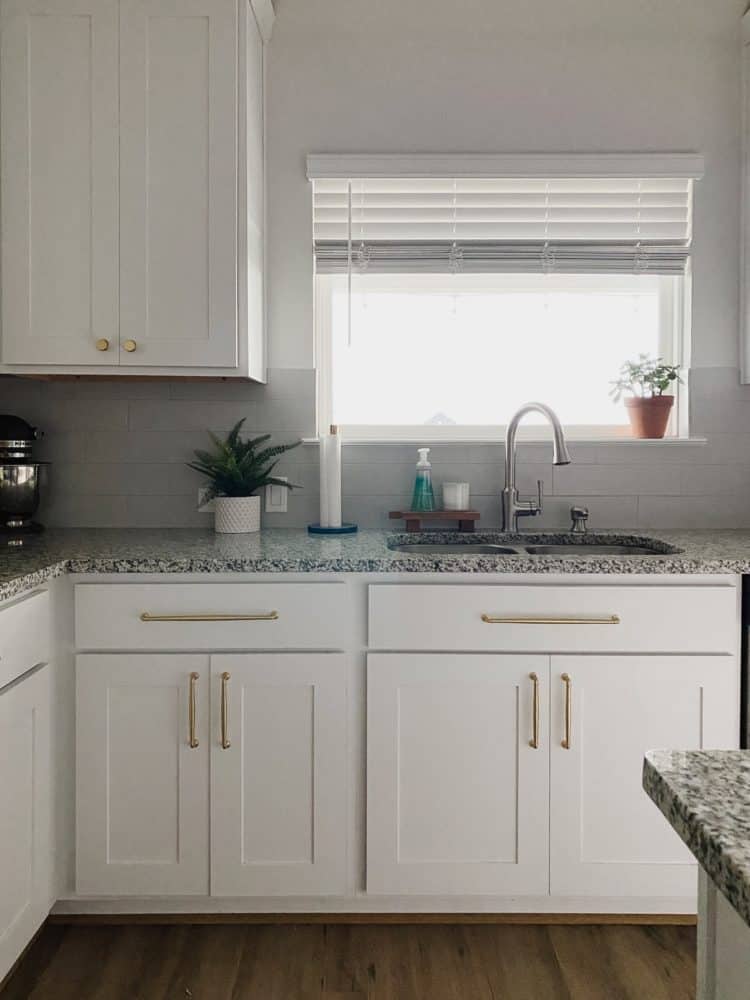 white kitchen with granite counters and gold hardware