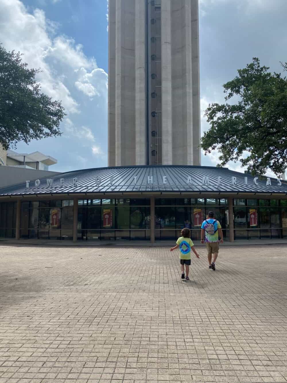 father and son walking up to the Tower of the Americas 