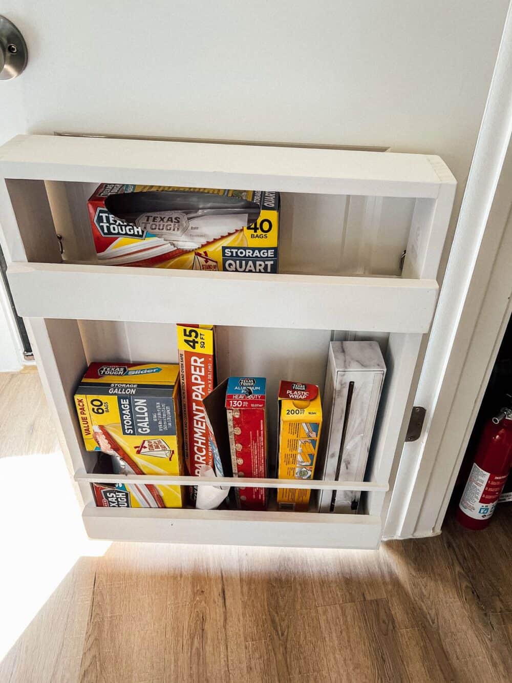 Pantry door with a wooden organizer for foil and plastic wrap