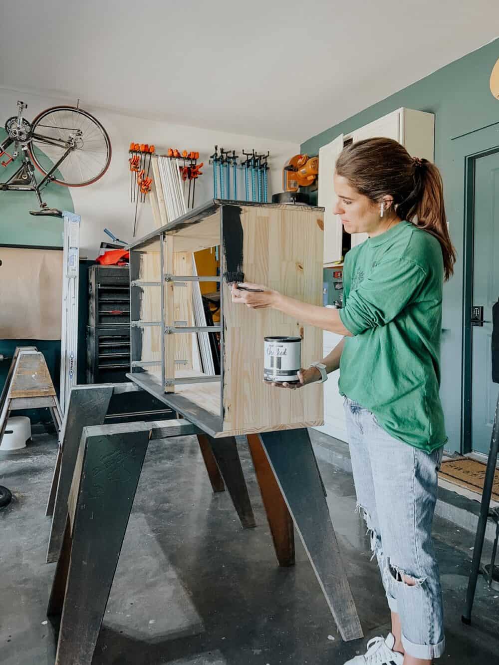 Woman painting an IKEA TARVA dresser with Rust-Oleum Chalked paint 