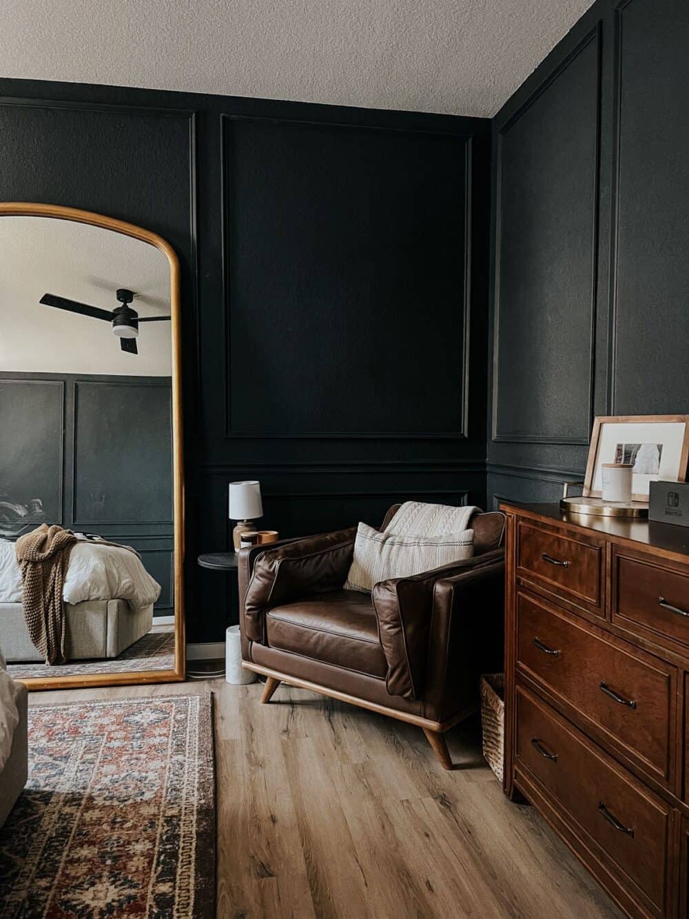 Dark and moody bedroom with molding on the walls 