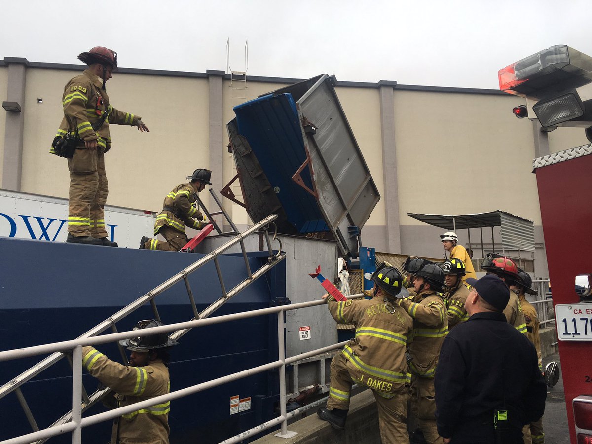 Firefighters remove person stuck inside trash compactor