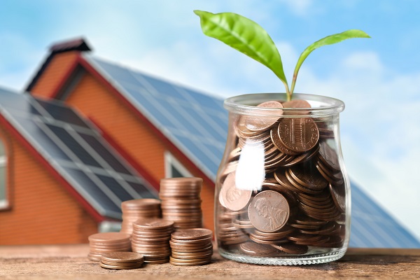 Ilustrasi Rumah dan Toples Kaca Berisi Uang Koin dan Daun Tanaman yang Bertumbuh Sebagai Ilustrasi Perkembangan atau Pertumbuhan dari Manfaat Penggunaan Energi Secara Alternatif