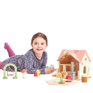 girl playing with pretty r cottage dolls house by tender leaf toys
