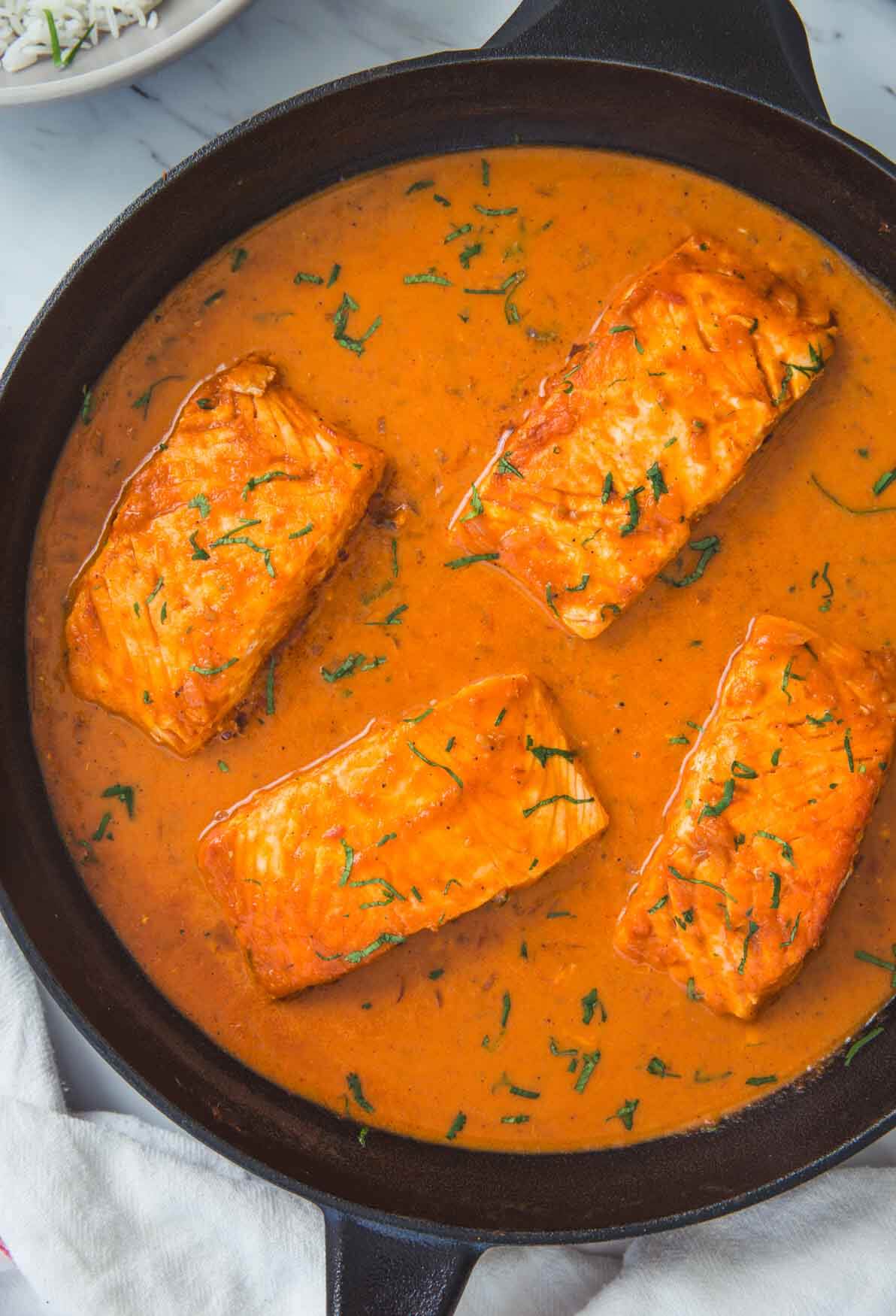 Ready to serve Indian salmon curry with coconut in cast iron skillet