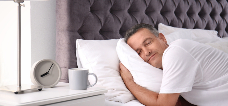Man sleeping on comfortable pillow in bed at home