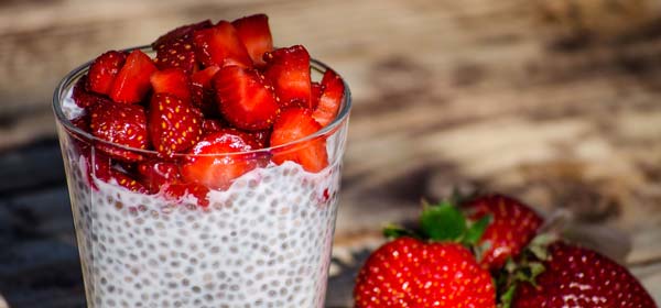 Strawberry chia pudding in glass on wooden table